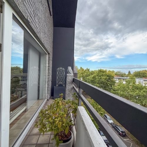 Schmaler Balkon mit Blumentöpfen in Krefeld und Zugang vom Wohnbereich.